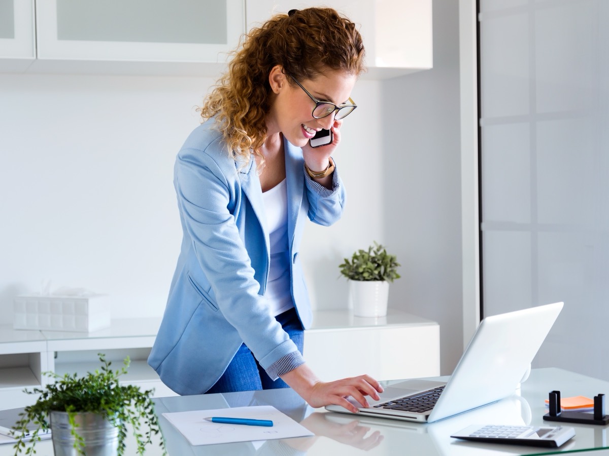 A realtor at her desk reviewing client follow-ups on a laptop
